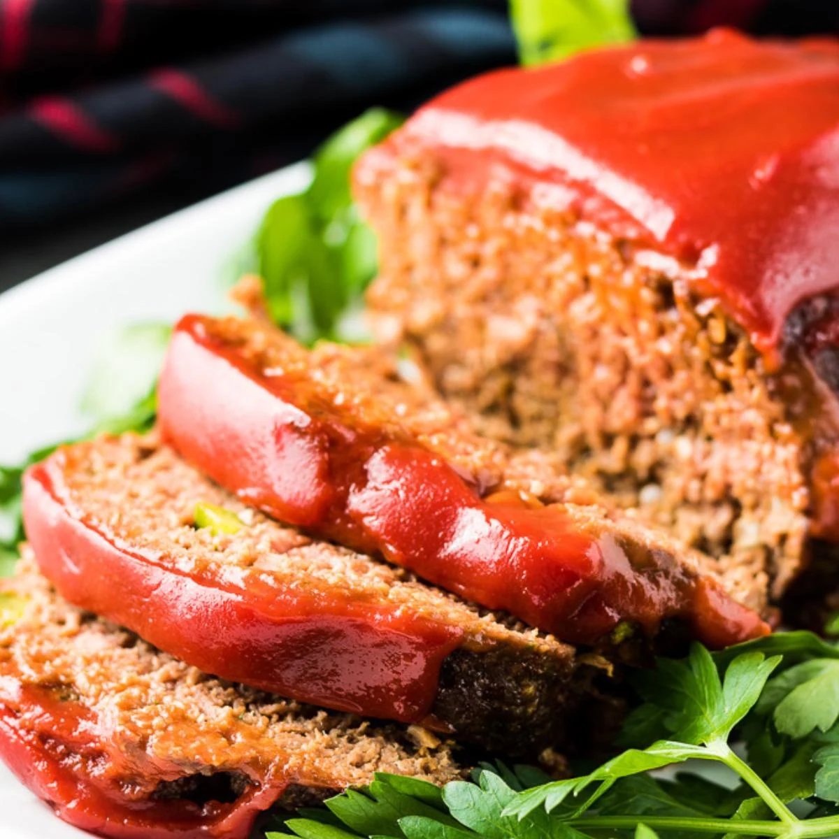 Close up view of sliced meatloaf on a platter.