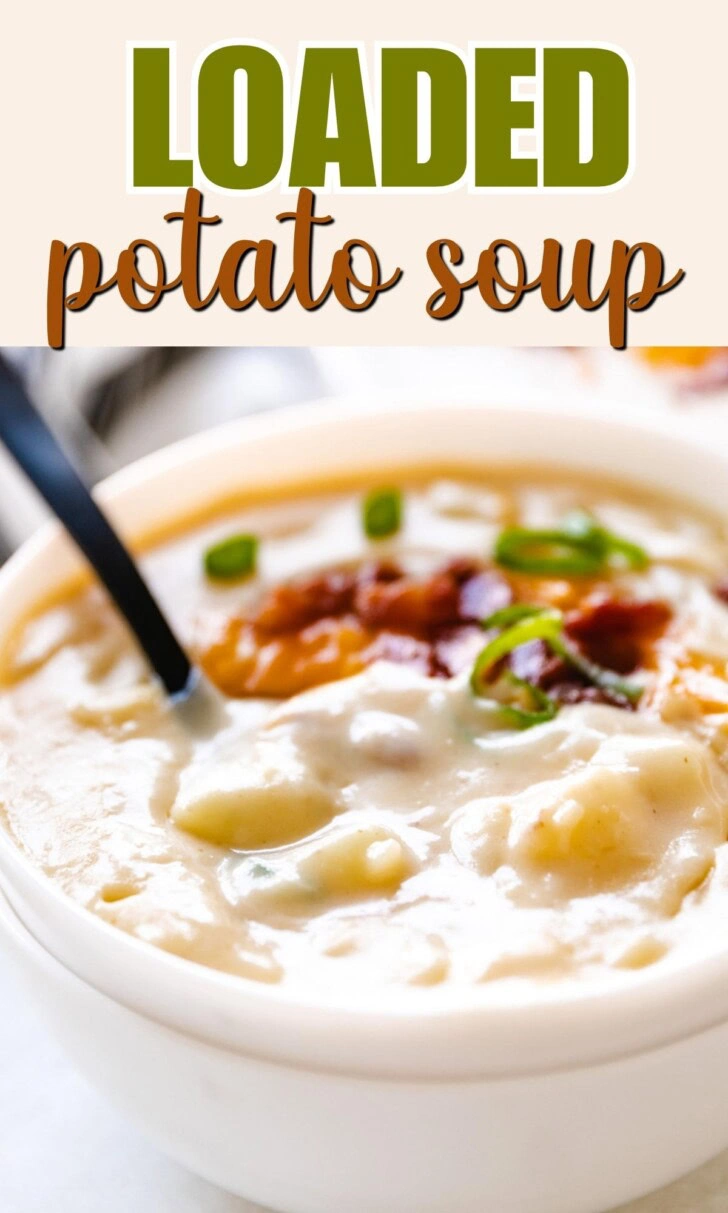 Spoon sitting in a bowl of potato soup.