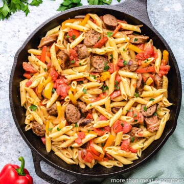 Overhead view of a skillet of sausage and peppers pasta.