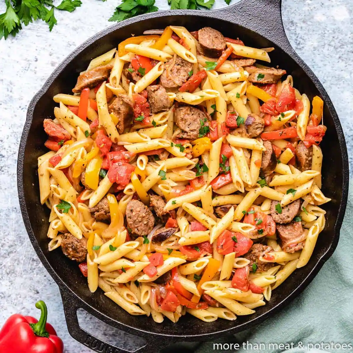 Overhead view of a skillet of sausage and peppers pasta.