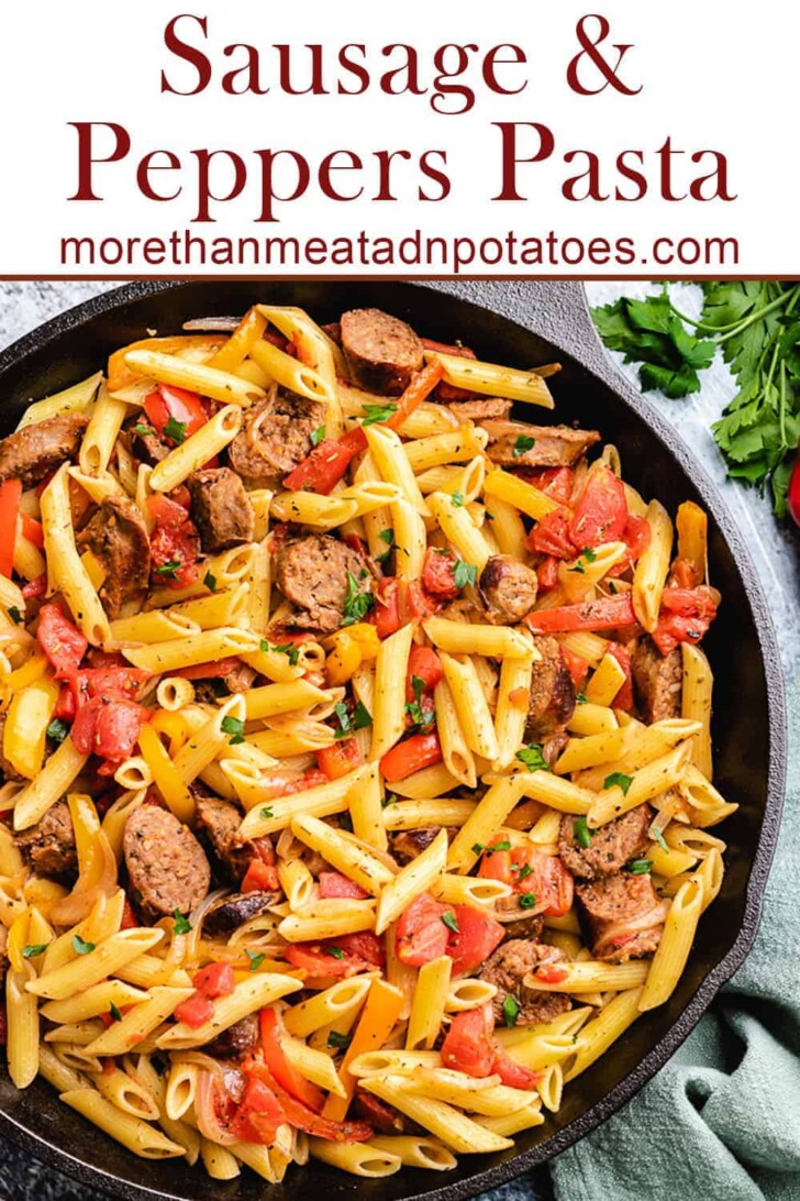 Close up view of a skillet filled with sausage and peppers pasta.
