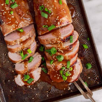 Overhead view of teriyaki pork tenderloin on a sheet pan.