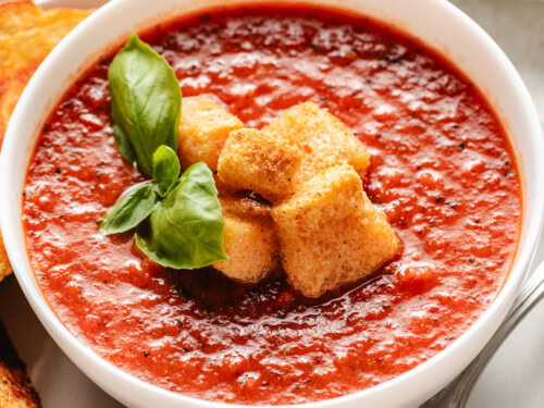 Close up view of tomato basil soup with croutons.
