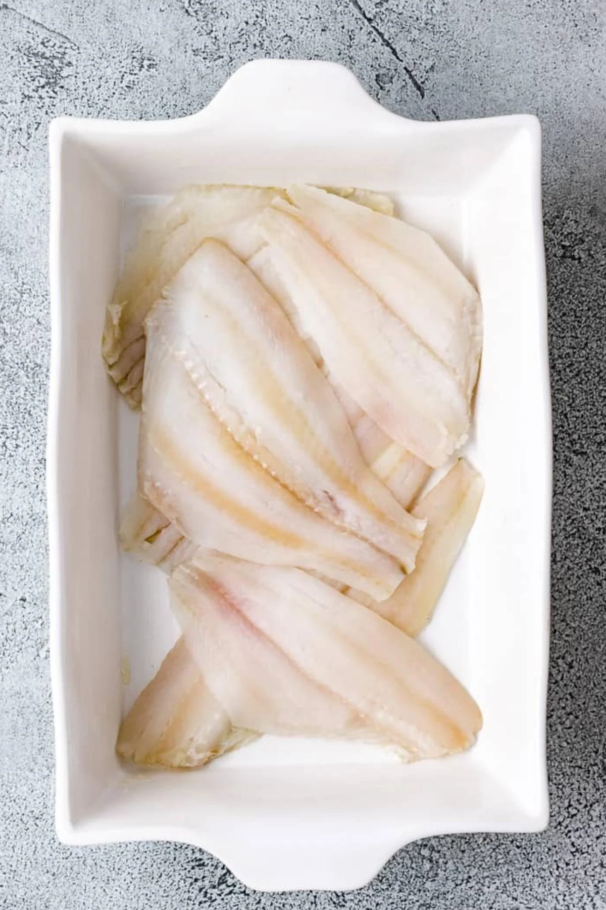 Flounder fillets in a baking pan.