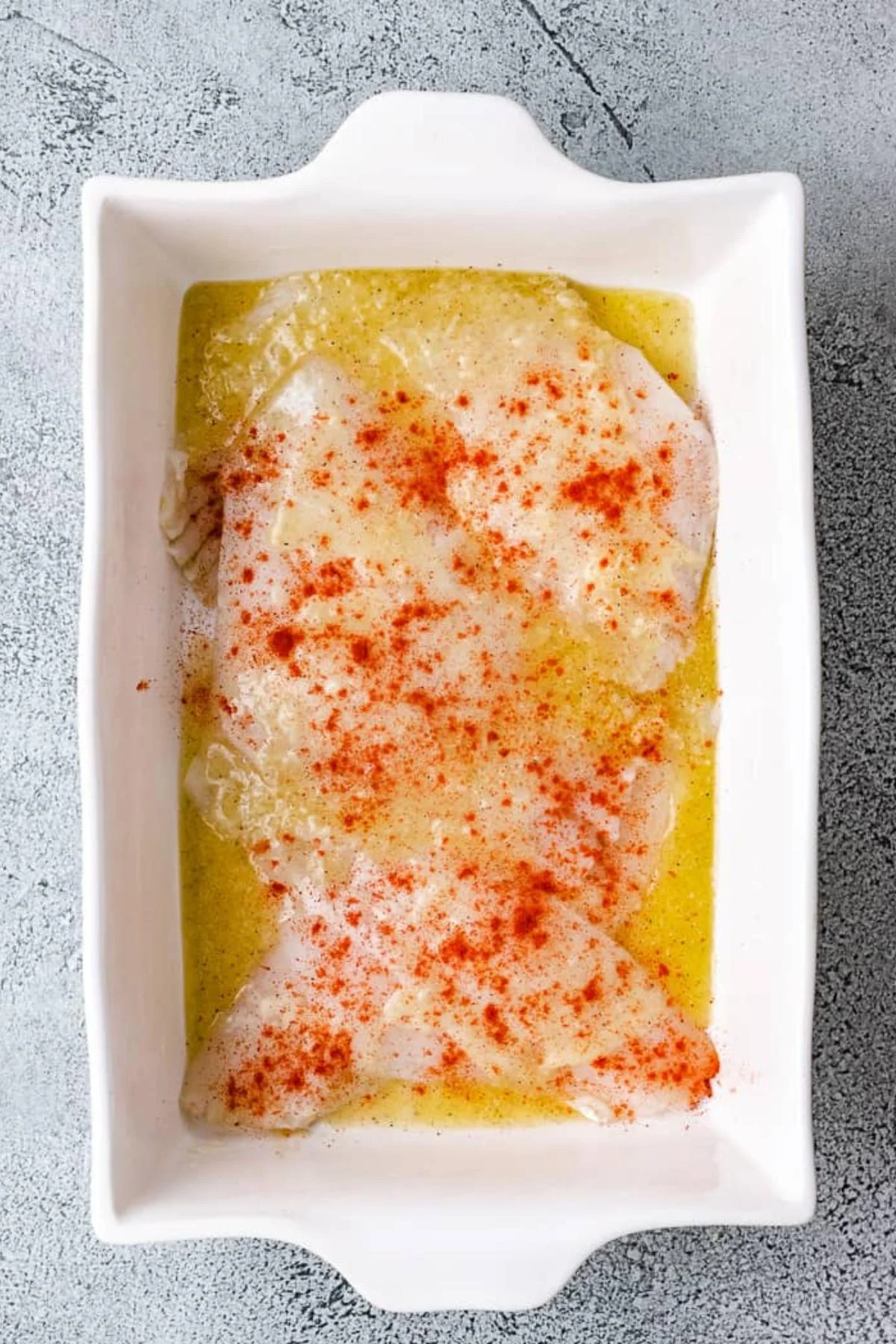 Paprika sprinkled over unbaked flounder.