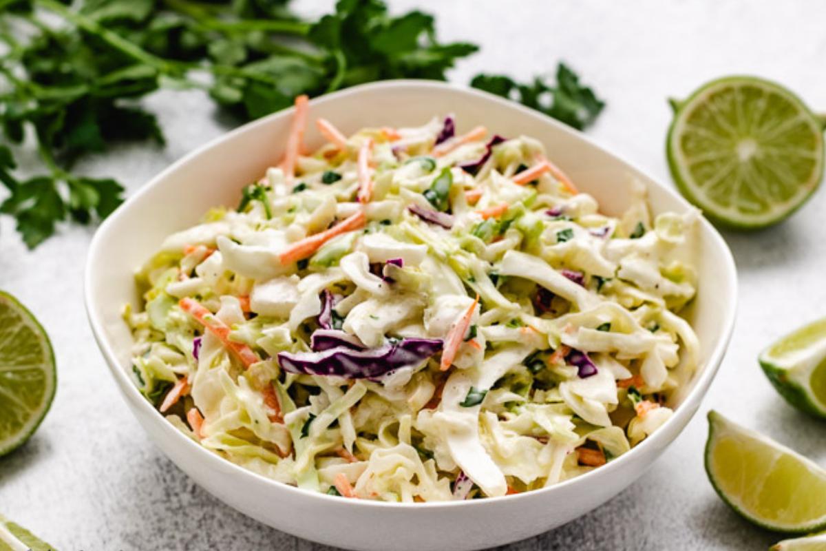 White bowl being filled with creamy fish taco slaw.