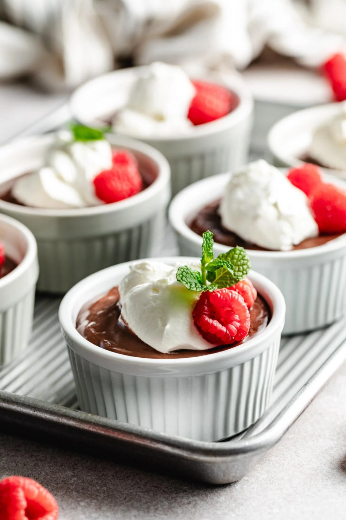 Ramekins of chocolate pudding on a baking sheet.