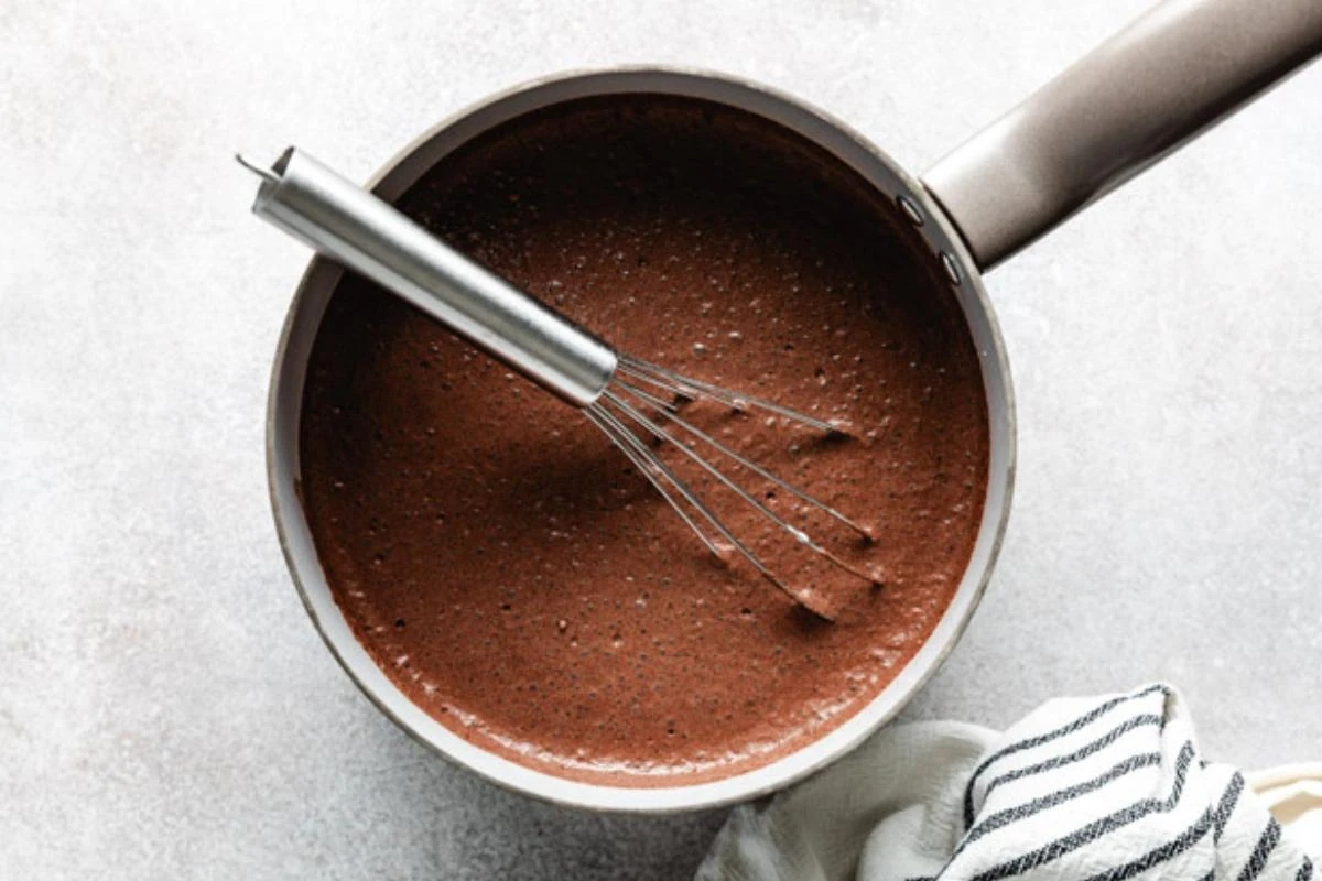 Milk and heavy cream added to dry ingredients for chocolate pudding.