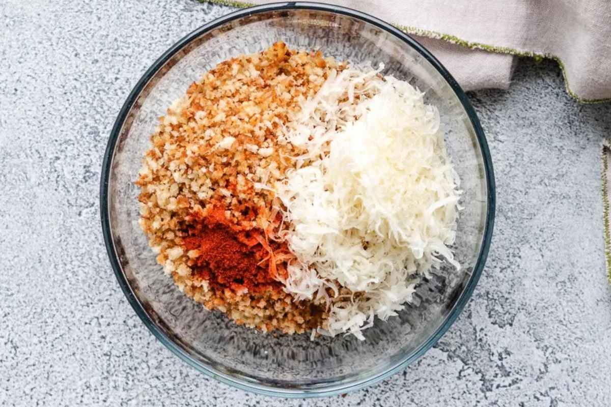 Toasted panko breadcrumbs, shredded parmesan cheese, and smoked paprika in a bowl.