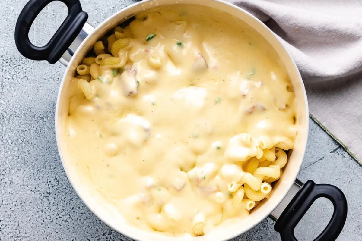 Jalape&ntilde;o bacon cheese sauce poured over a pan of pasta noodles.