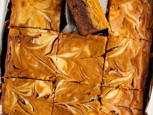 Overhead view of a pan of swirled pumpkin cheesecake brownies.