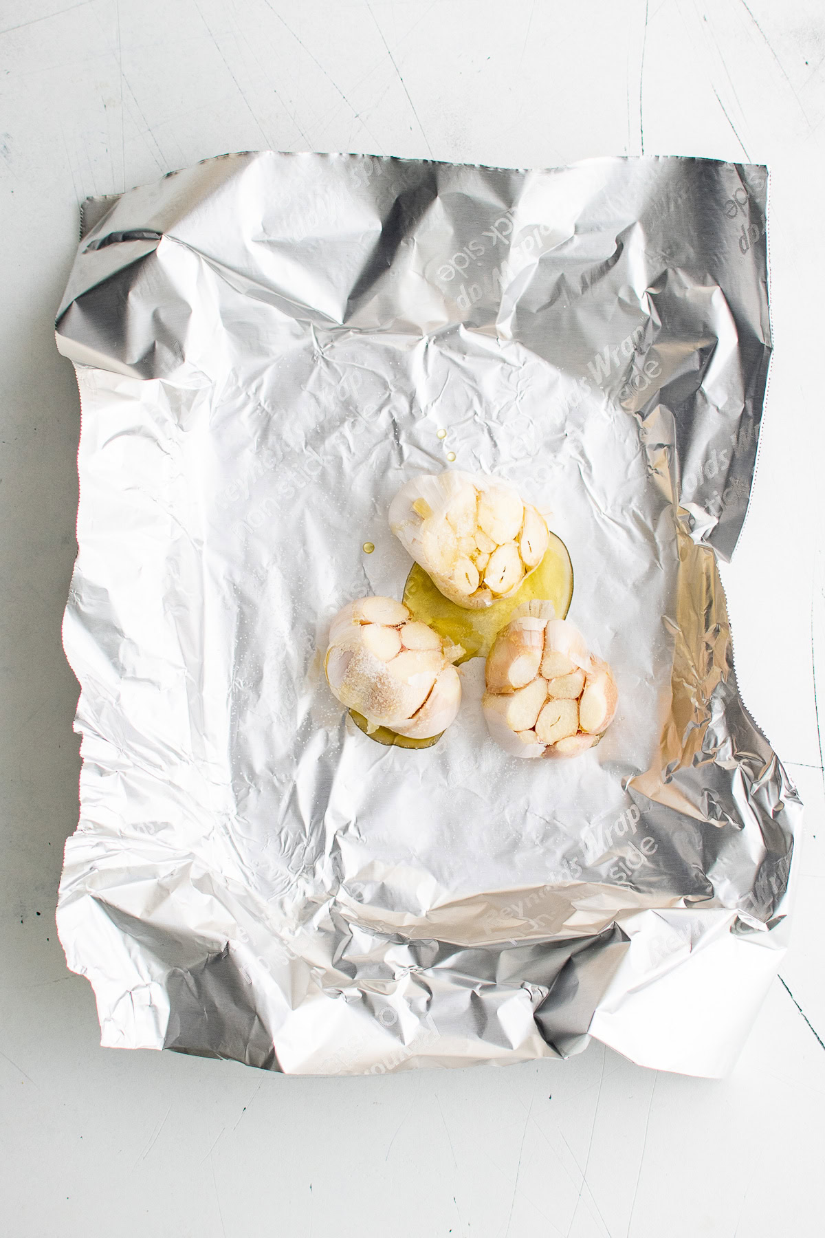 Bulbs of garlic drizzled with olive oil.