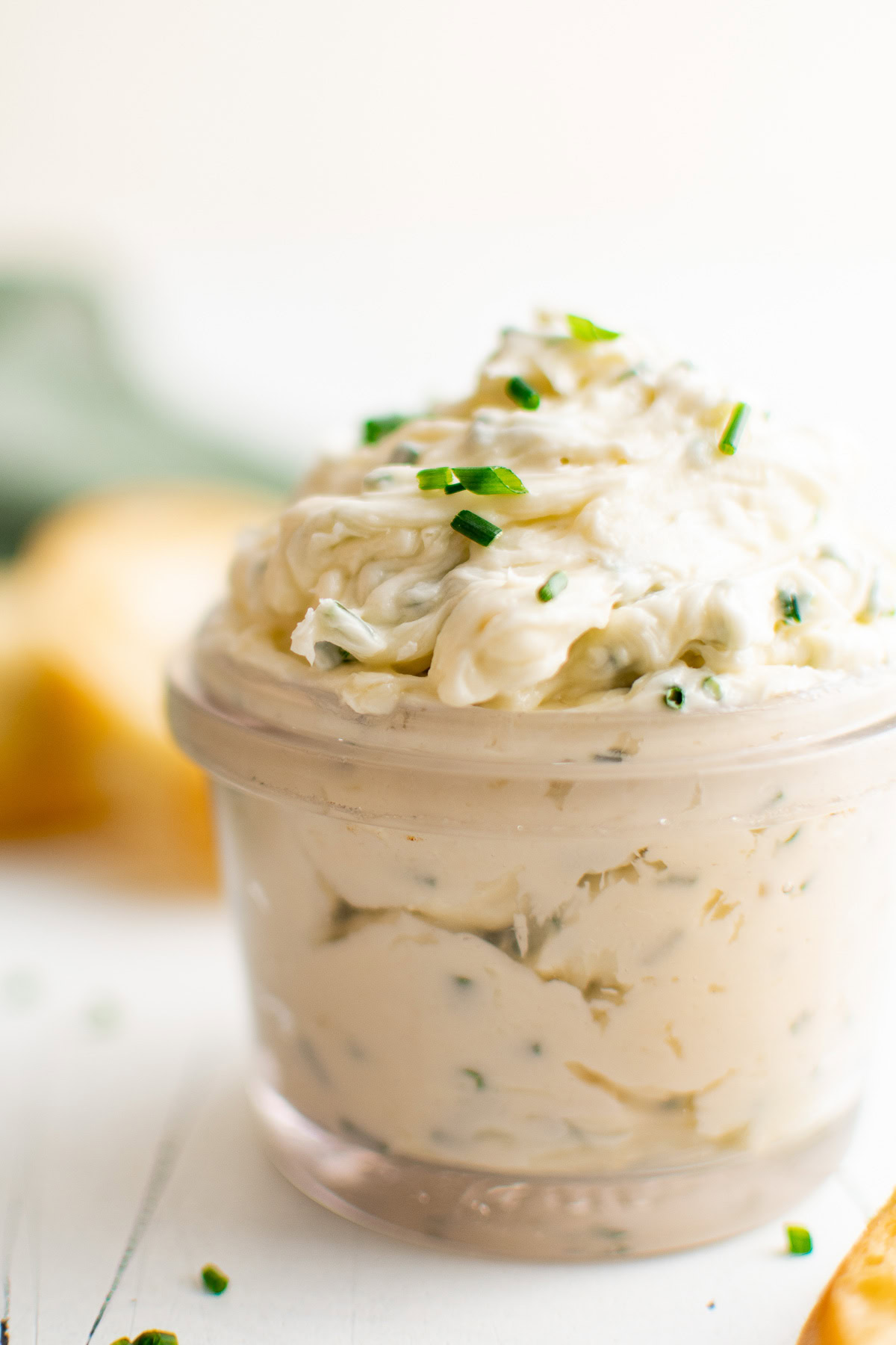 Close up view of a glass jar filled with roasted garlic butter.