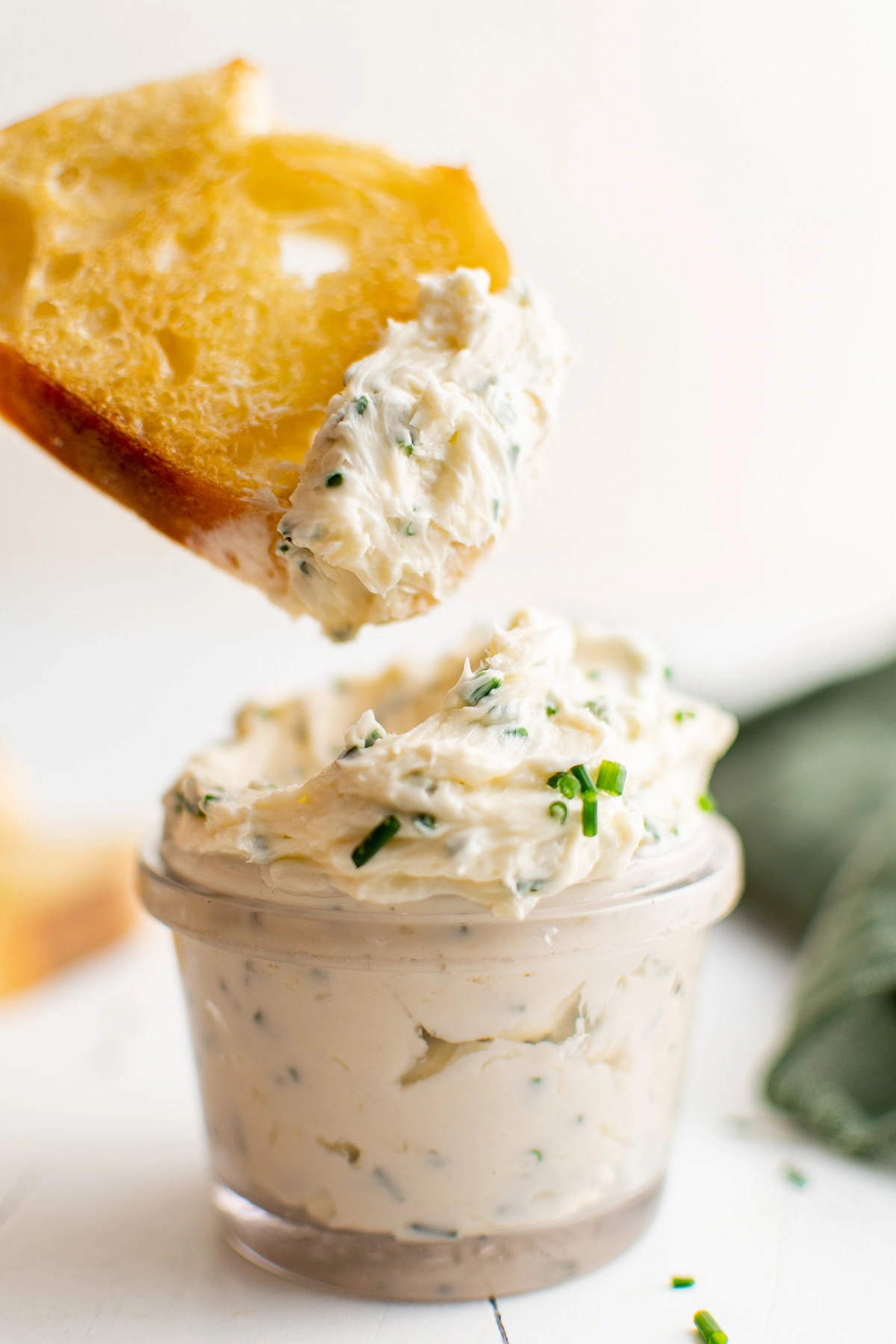 Bread dipping into a jar of butter.