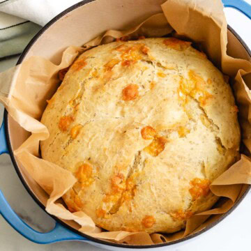 Overhead view of a loaf of rosemary parmesan bread in a Dutch oven.